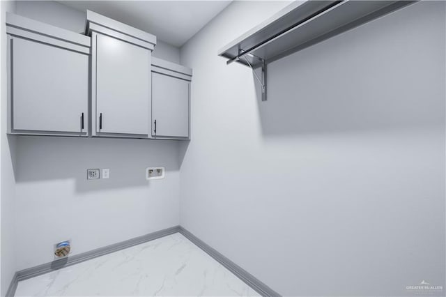 laundry room with hookup for a washing machine, cabinet space, marble finish floor, and baseboards