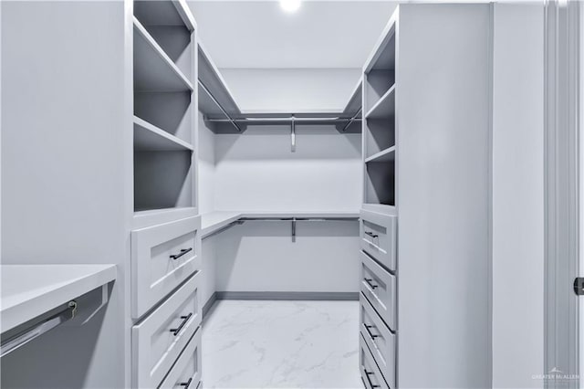 walk in closet with marble finish floor
