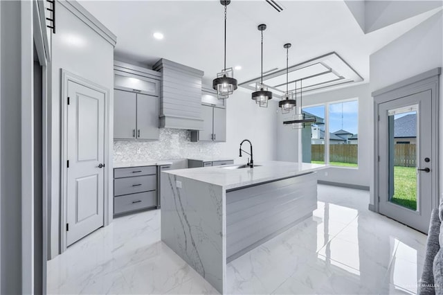 kitchen featuring gray cabinets, marble finish floor, and a sink