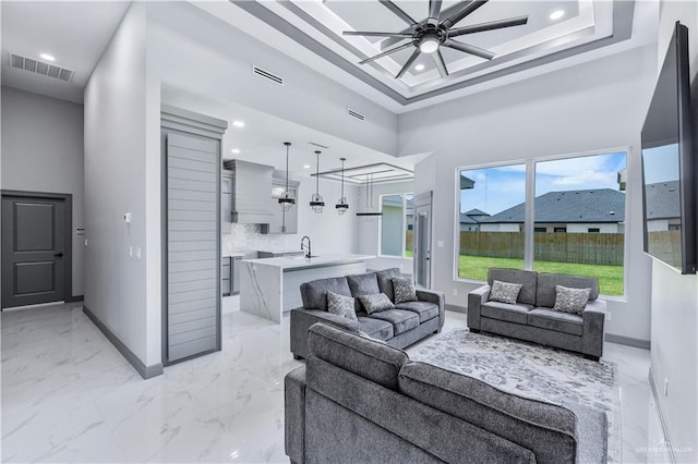 living area with baseboards, visible vents, ceiling fan, and marble finish floor