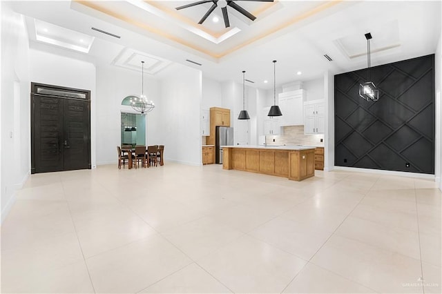 bathroom featuring decorative backsplash, tile patterned floors, ceiling fan with notable chandelier, and a raised ceiling