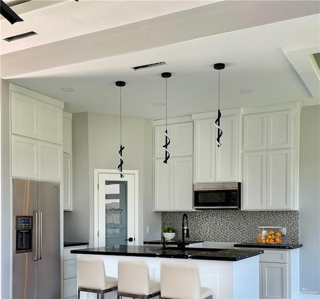 532 Demi St, Edinburg, TX 78542 - kitchen with stainless steel appliances, backsplash, white cabinetry, and decorative light fixtures