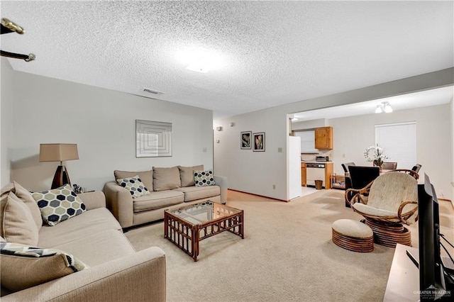 carpeted living room featuring a textured ceiling