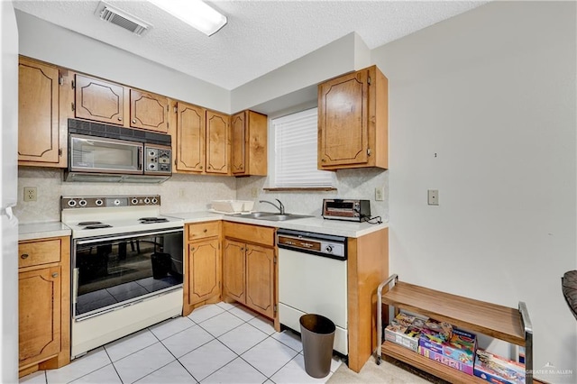 kitchen featuring light tile patterned floors, decorative backsplash, white appliances, a textured ceiling, and sink