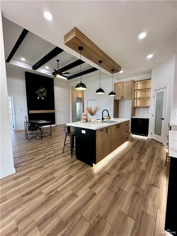 2413 N Woody St, Edinburg, TX 78541 - kitchen featuring a sink, beamed ceiling, a ceiling fan, light countertops, and open floor plan