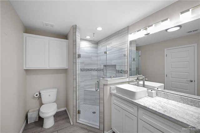 full bathroom featuring visible vents, toilet, a shower stall, and vanity