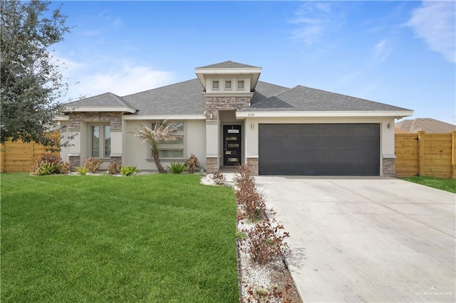 prairie-style house featuring a garage, concrete driveway, a front yard, and fence