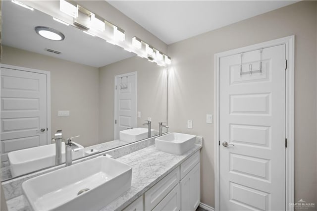 full bathroom featuring double vanity, visible vents, and a sink