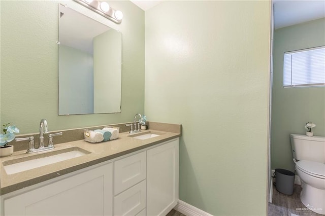 bathroom with wood-type flooring, vanity, and toilet