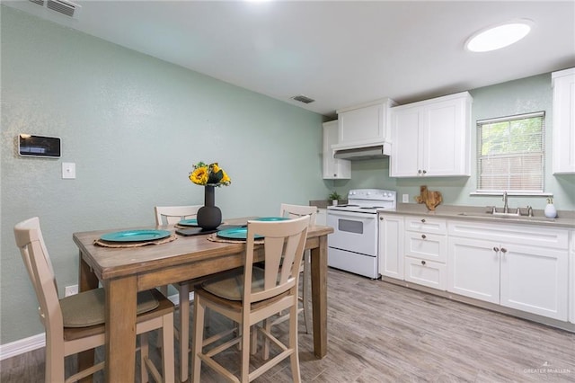 kitchen featuring sink, white cabinets, light wood-type flooring, and white electric range