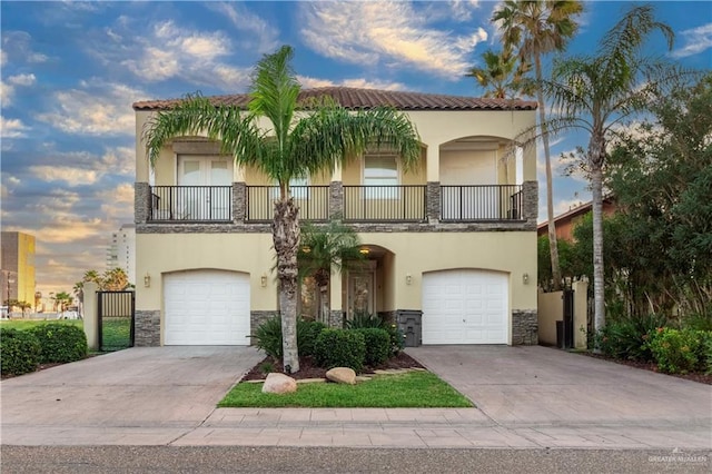 mediterranean / spanish home featuring a balcony and a garage