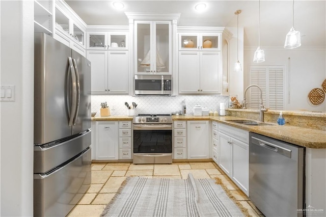 kitchen with hanging light fixtures, sink, decorative backsplash, appliances with stainless steel finishes, and white cabinetry