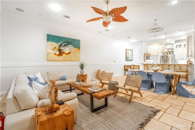 living room with ceiling fan with notable chandelier and ornamental molding