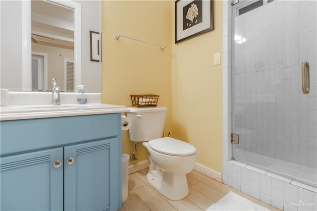 bathroom featuring vanity, toilet, and a shower with door