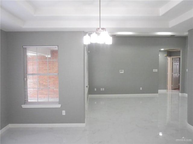 unfurnished room with a raised ceiling and an inviting chandelier