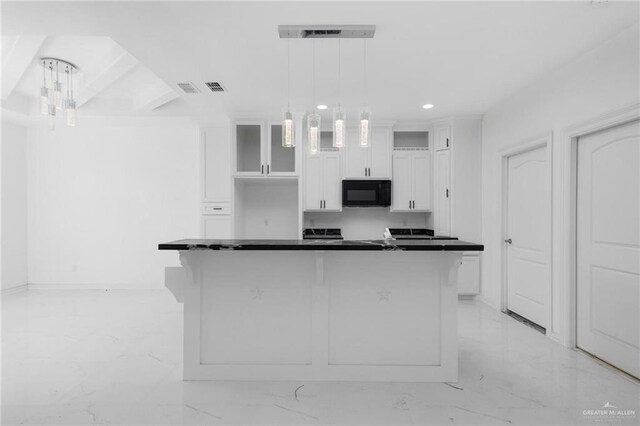 kitchen featuring white cabinets, decorative light fixtures, and a kitchen island