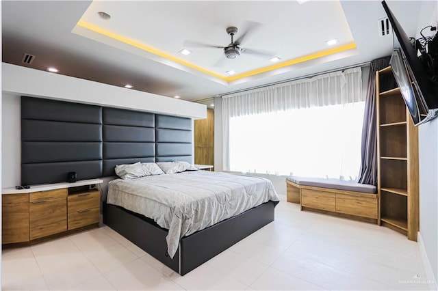 bedroom featuring ceiling fan and a raised ceiling