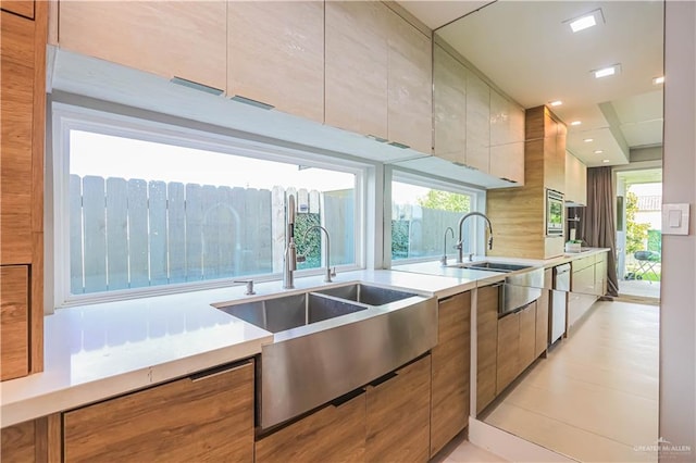 kitchen featuring plenty of natural light, light tile patterned floors, sink, and appliances with stainless steel finishes