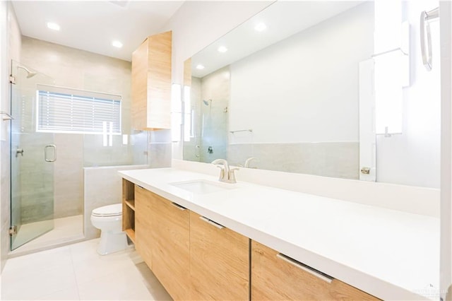 bathroom featuring tile patterned floors, vanity, toilet, and a shower with shower door