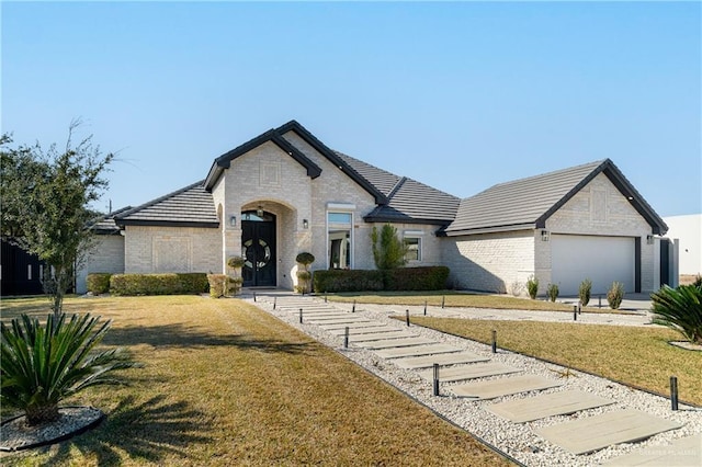 french country home with a garage and a front lawn