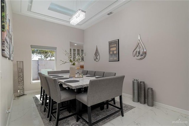 dining area with a raised ceiling and a towering ceiling