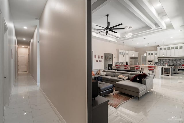 living room with ceiling fan and a tray ceiling