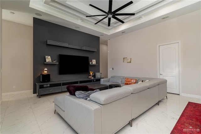 living room featuring ceiling fan and a raised ceiling