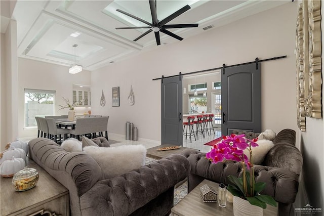 living room with a barn door, coffered ceiling, and ceiling fan