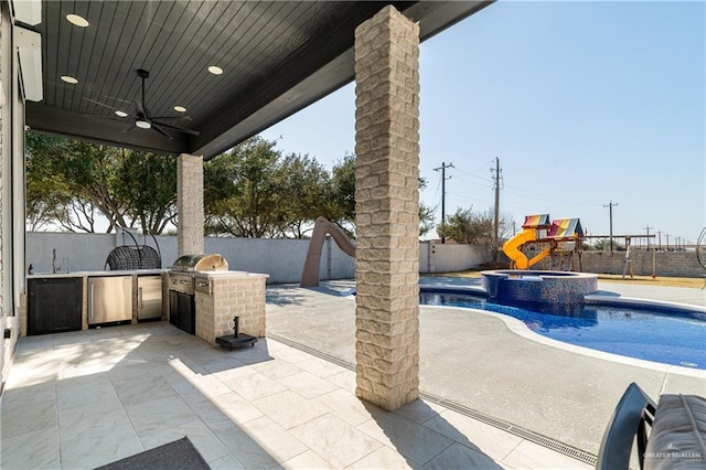 view of patio featuring area for grilling, ceiling fan, a playground, and a grill