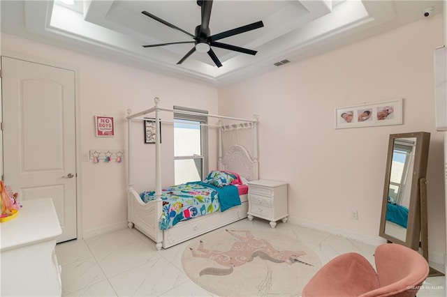 bedroom with a tray ceiling and ceiling fan