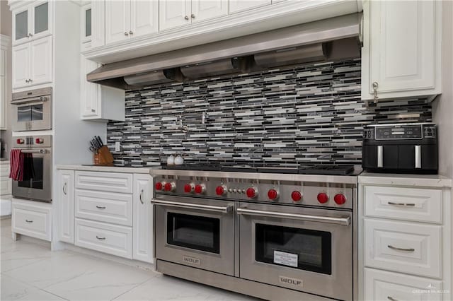 kitchen featuring white cabinetry, appliances with stainless steel finishes, and backsplash