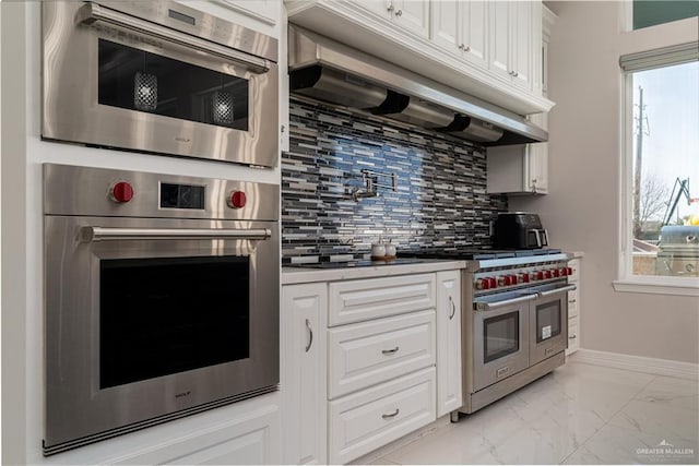 kitchen with white cabinetry, appliances with stainless steel finishes, and backsplash