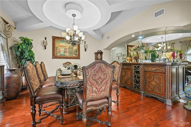 dining area with wood finished floors, visible vents, arched walkways, and a notable chandelier