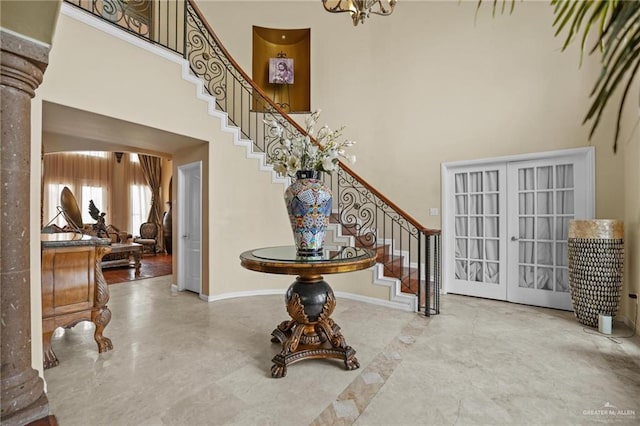entryway with stairway, a high ceiling, an inviting chandelier, french doors, and baseboards