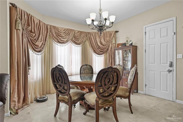 dining space featuring an inviting chandelier and baseboards