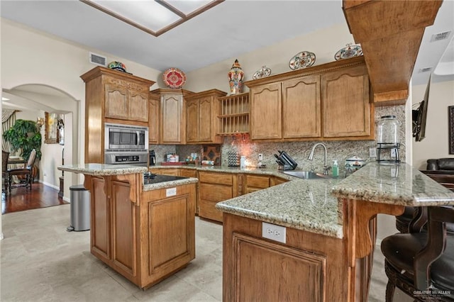 kitchen featuring a breakfast bar area, visible vents, a sink, and appliances with stainless steel finishes