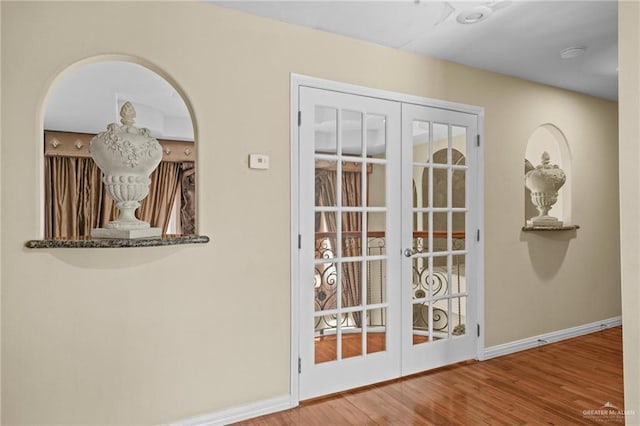 entryway with baseboards, french doors, and wood finished floors
