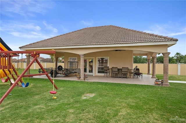 back of property with a fenced backyard, a patio area, a ceiling fan, and a playground