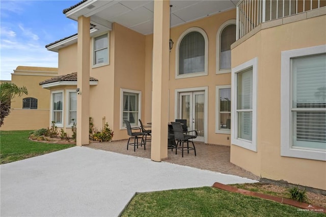 rear view of house featuring a patio and stucco siding