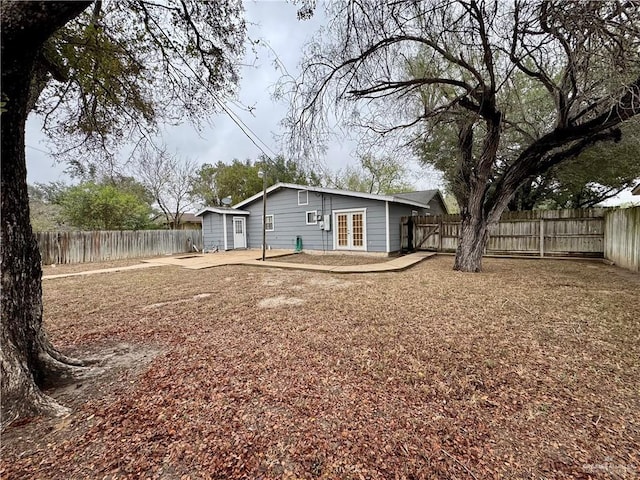 rear view of property with french doors, a patio area, and a fenced backyard