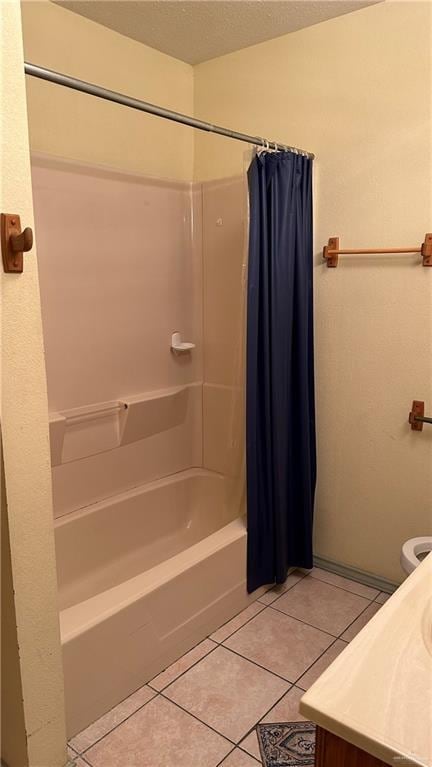 bathroom featuring toilet, shower / tub combo, vanity, a textured ceiling, and tile patterned floors