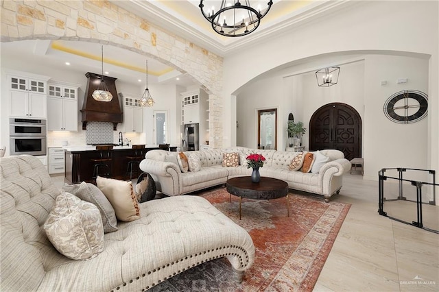 living area with arched walkways, a chandelier, recessed lighting, and a towering ceiling