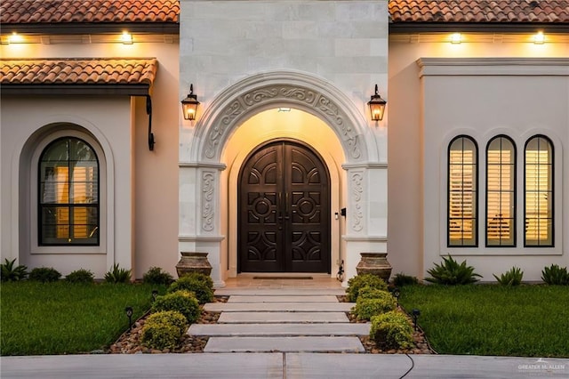 property entrance featuring stucco siding and a tiled roof