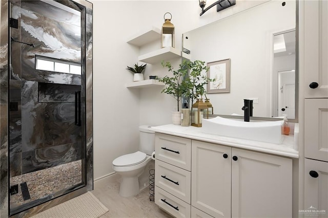 bathroom featuring vanity, a stall shower, and toilet