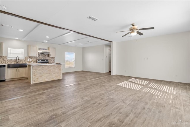 unfurnished living room featuring ceiling fan, sink, and light wood-type flooring