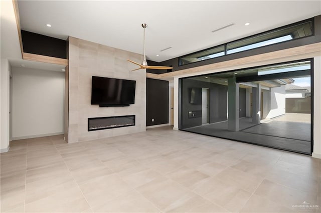 unfurnished living room featuring a tiled fireplace and light tile patterned flooring