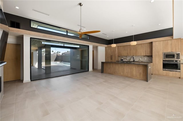 kitchen with decorative light fixtures, light tile patterned flooring, appliances with stainless steel finishes, and tasteful backsplash