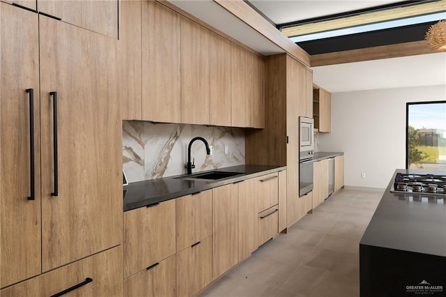 kitchen with decorative backsplash, sink, light brown cabinetry, and stainless steel appliances