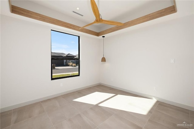 tiled empty room with a raised ceiling