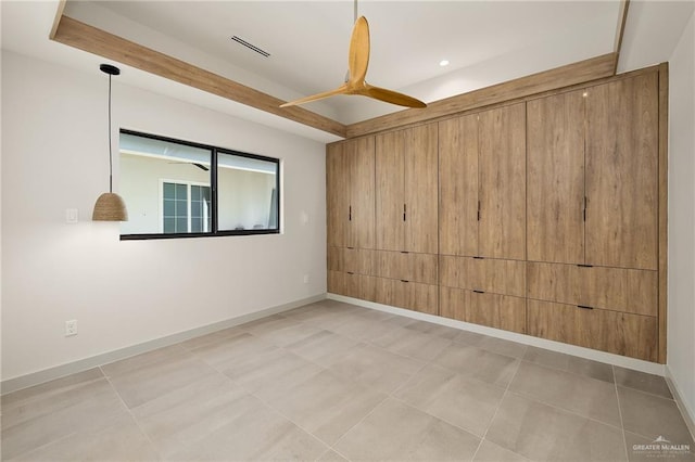 empty room with ceiling fan and light tile patterned floors